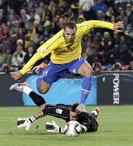 Brazil's Luis Fabiano, top, dribbels past Chile goalkeeper Claudio Bravo, bottom, to score his side's second goal during the World Cup round of 16 soccer match between Brazil and Chile at Ellis Park Stadium in Johannesburg, South Africa, Monday, June 28, 2010.